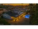 Sunset aerial view of house with solar panels, backyard pool, covered patio, and meticulous landscaping at 5916 E Hearn Rd, Scottsdale, AZ 85254