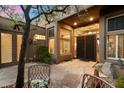 Inviting courtyard with stone tile, potted plants, outdoor seating, and a decorative iron gate at 11082 E Mark Ln, Scottsdale, AZ 85262