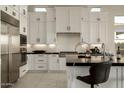 Bright kitchen with white cabinets, stainless steel appliances, and sleek black countertops at 12245 E Clinton St, Scottsdale, AZ 85259