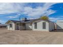 Rear exterior view, featuring neutral paint, dark trim, and a large gravel backyard and storage unit at 1401 N Houck St, Casa Grande, AZ 85122