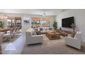 Staged living room with comfortable seating, neutral colors, and access to outdoor dining area at 14817 W Domingo Ln, Sun City West, AZ 85375