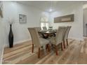 Elegant dining room featuring a stylish table with six chairs, wood floors, and decorative accents at 15021 N 7Th Dr, Phoenix, AZ 85023