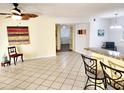 Living room featuring ceramic tile flooring, breakfast bar, and neutral paint at 16402 N 31St St # 134, Phoenix, AZ 85032