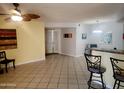Open-concept living room with bar seating and tile floors, creating a seamless flow for modern living at 16402 N 31St St # 134, Phoenix, AZ 85032