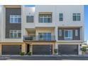 Contemporary townhome featuring stone accents, dark garage doors, and a private balcony with iron railings at 1717 E Morten Ave # 16, Phoenix, AZ 85020