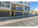 Contemporary townhome featuring stone accents, dark garage doors, and a private balcony with iron railings at 1717 E Morten Ave # 16, Phoenix, AZ 85020