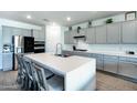 Bright kitchen with gray cabinetry, stainless steel appliances, and large island with seating at 17310 W Seldon Ln, Waddell, AZ 85355