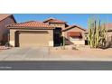 Charming single-Gathering home features a two-car garage, red tile roof, and xeriscaped front yard with desert landscaping at 18080 W Udall Dr, Surprise, AZ 85374