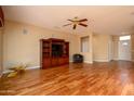 Bright living room with hardwood floors, a ceiling fan, and a media center at 18400 N Deer Grass Ct, Surprise, AZ 85374