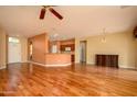 Open concept living room with hardwood floors connects to the kitchen through a breakfast bar at 18400 N Deer Grass Ct, Surprise, AZ 85374