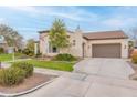 Inviting home featuring an attached garage, tile roof, lush lawn, and mature landscaping at 20618 W Western Dr, Buckeye, AZ 85396