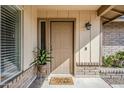 Covered entry with a tan door and a decorative plant, with a 'stay awhile' door mat at 3632 W Kelton Ln, Phoenix, AZ 85053