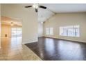 Bright living room featuring dark wood floors, large windows and a vaulted ceiling with ceiling fans at 3632 W Kelton Ln, Phoenix, AZ 85053