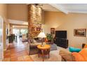 Spacious living room with a stunning stone fireplace, tile floors, and an open layout to the kitchen at 5824 N Scottsdale Rd, Paradise Valley, AZ 85253