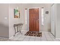 Bright foyer featuring tile flooring, a decorative table, a mirror, and a wood door, creating a welcoming entrance at 7454 E Pueblo Ave, Mesa, AZ 85208