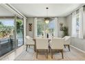 Bright dining area with sliding glass doors to the backyard, stylish light fixture, and seating for six at 8516 W Peppertree Ln, Glendale, AZ 85305