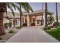 Captivating shot of the home's front exterior, highlighting a columned entrance and desert landscaping at 9128 N 70Th St, Paradise Valley, AZ 85253
