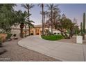 Beautiful home showcasing lush landscaping and a long driveway leading to the grand entrance at 9128 N 70Th St, Paradise Valley, AZ 85253