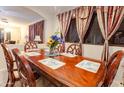 Elegant dining room showcasing a wooden table with seating for six, decorative window treatments, and neutral wall tones at 11197 W Coronado Rd, Avondale, AZ 85392