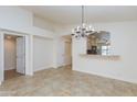 Open-concept dining room features ceramic tile flooring, neutral walls, a chandelier, and open view to kitchen at 12224 N Gambel Dr, Fountain Hills, AZ 85268