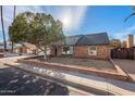 Well-maintained single-Gathering home with brick facade, mature tree, and desert landscaping at 1767 W Kiowa Ave, Mesa, AZ 85202