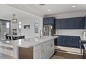 Modern kitchen featuring navy cabinets, a quartz island and stainless steel appliances at 23282 S 229Th Pl, Queen Creek, AZ 85142