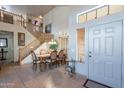 Elegant dining area with staircase, tile flooring, and abundant natural light at 2528 W Mericrest Way, San Tan Valley, AZ 85144