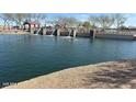 This is a view of the community lake and dammed waterfall with a covered picnic area in the background at 36840 W San Clemente St, Maricopa, AZ 85138