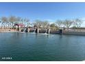 This is a view of the community lake and dammed waterfall with a covered picnic area in the background at 36840 W San Clemente St, Maricopa, AZ 85138