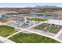 Aerial view of community park featuring playground, picnic area, basketball court, and cornhole at 37053 W La Paz St, Maricopa, AZ 85138
