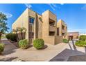 Condominium exterior view showcasing lush landscaping and concrete sidewalks at 5877 N Granite Reef Rd # 2203, Scottsdale, AZ 85250