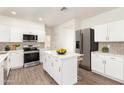 Stylish kitchen with white cabinets, stainless steel appliances, and a kitchen island at 6338 W Hilton Ave, Phoenix, AZ 85043