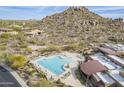 Aerial view of a community pool surrounded by lounge chairs and lush desert landscaping at 7321 E Crimson Sky Trl, Scottsdale, AZ 85266