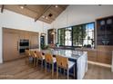 The modern kitchen showcases a spacious island, custom wood cabinetry, stainless steel appliances, and sleek design at 7508 E Laredo Ln, Scottsdale, AZ 85250