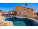 Backyard pool with privacy fence, covered patio, and desert landscaping at 9230 W Grovers Ave, Peoria, AZ 85382