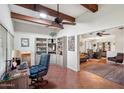 Versatile office space with built-in bookshelves, wood beam ceiling, and an adjacent living area at 9802 W Shasta Dr, Sun City, AZ 85351