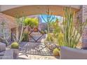 Inviting courtyard entrance featuring desert landscaping, a stone pathway, and a decorative iron gate at 10040 E Happy Valley Rd # 449, Scottsdale, AZ 85255