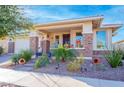 Inviting front porch features decorative brick accents and colorful potted plants for a cheerful welcome at 10545 E Texas Ave, Mesa, AZ 85212