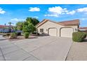 View of a two car garage with an expansive driveway and desert landscaping at 10895 E Mission Ln, Scottsdale, AZ 85259