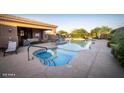 Community pool area featuring a jacuzzi, comfortable outdoor furniture, and desert landscape at 13044 N Northstar Dr, Fountain Hills, AZ 85268