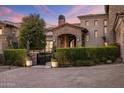 Elegant stone home with a brick archway, manicured hedges, and a gated entry at 13808 S Canyon Dr, Phoenix, AZ 85048