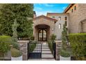 Charming home featuring a stone archway, manicured greenery, and a gated entryway at 13808 S Canyon Dr, Phoenix, AZ 85048