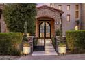 Attractive stone archway entrance featuring a black metal gate and manicured greenery at 13808 S Canyon Dr, Phoenix, AZ 85048