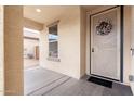 Inviting entryway features a charming storm door with wreath, window and concrete flooring at 16789 W Moreland St, Goodyear, AZ 85338