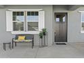 Inviting front porch area with seating, stylish decor, and a dark front door at 17205 W Middlebury St, Surprise, AZ 85388