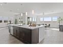 Spacious kitchen island with barstool seating, undermount sink, and stainless steel dishwasher at 17205 W Middlebury St, Surprise, AZ 85388