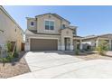 Two-story home with a neutral exterior, a two-car garage, and low-maintenance desert landscaping in the front yard at 17745 W Carol Ave, Waddell, AZ 85355