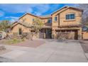 Elegant two-story home featuring a desert landscape, stone accents and a gated entry at 18430 E Ashridge Dr, Queen Creek, AZ 85142