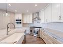 Contemporary kitchen featuring custom cabinets, stainless steel appliances, and stylish tile backsplash at 18430 E Ashridge Dr, Queen Creek, AZ 85142