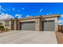 Charming home exterior with a stone facade, neutral color palette, and a spacious three-car garage at 18434 W Chama Dr, Surprise, AZ 85387